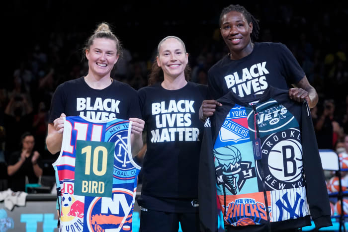 Sue Bird poses with Liberty players, who are holding gifts for the Storm star